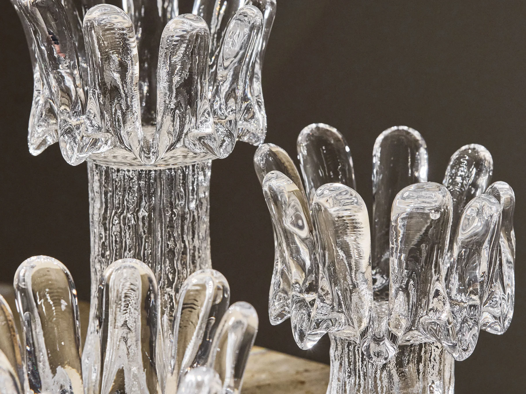 Two clear glass decorative objects with textured, ice-like surfaces and petal-like openings.
